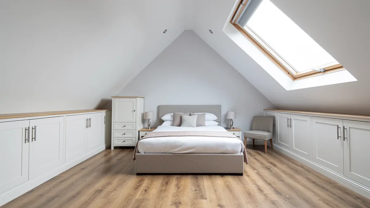 Illustrative hip-to-gable loft bedroom with eaves storage and a roof window, the kind of conversion that suits Goring-by-Sea's hipped-roof 1930s semis